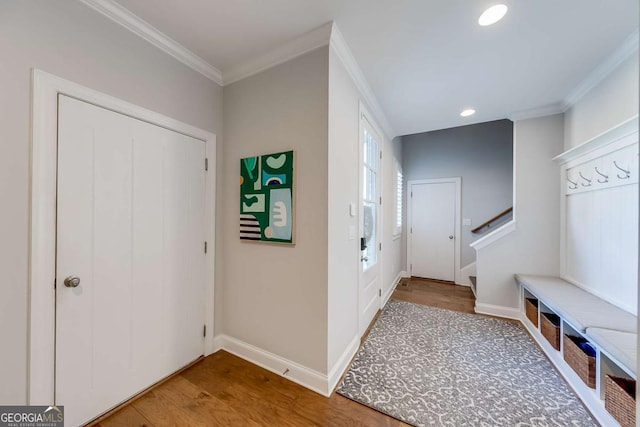 mudroom featuring crown molding, baseboards, and wood finished floors