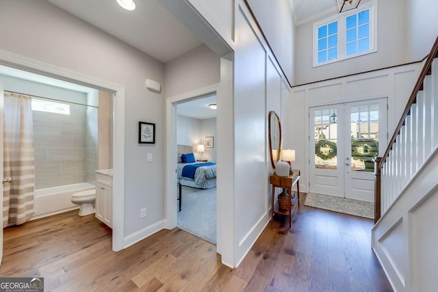 entrance foyer featuring stairs, french doors, light wood-type flooring, and baseboards