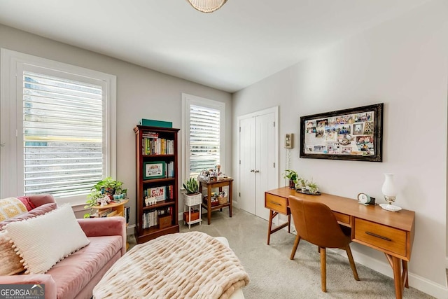 office space with baseboards and light colored carpet