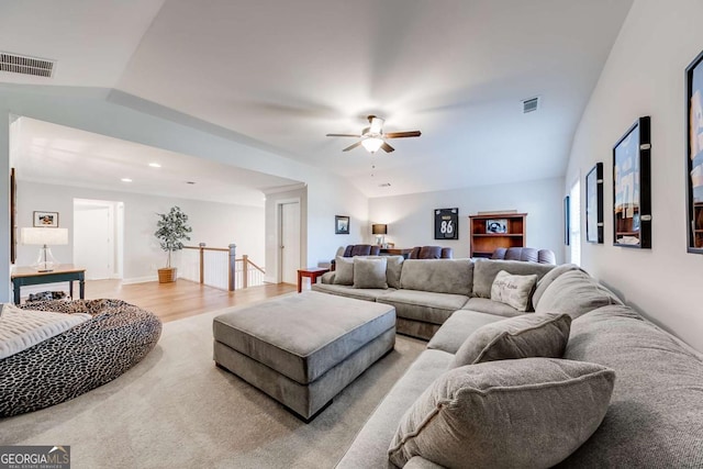 living area featuring vaulted ceiling, visible vents, and light wood-style floors