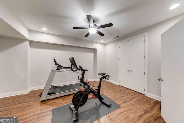 exercise area featuring recessed lighting, wood finished floors, and baseboards