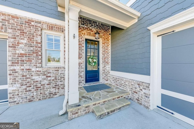 property entrance featuring brick siding