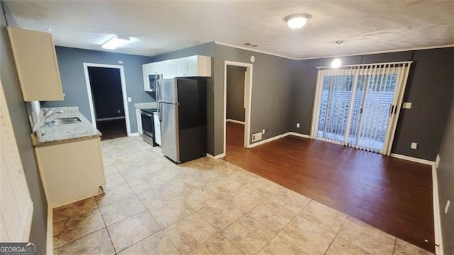 kitchen featuring light wood-type flooring, stainless steel appliances, sink, white cabinetry, and hanging light fixtures