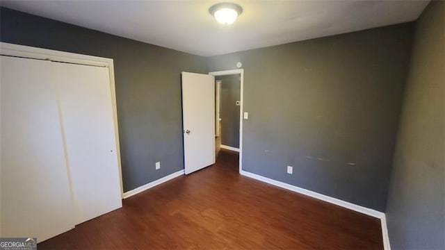 unfurnished bedroom featuring dark hardwood / wood-style floors and a closet