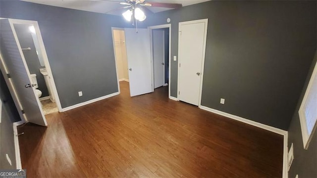 unfurnished bedroom with dark hardwood / wood-style floors, ceiling fan, and connected bathroom