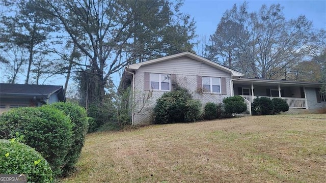 view of side of property featuring a porch and a yard