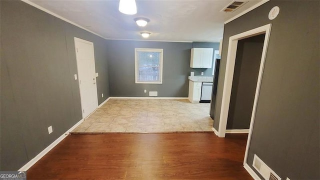 interior space with crown molding and light hardwood / wood-style flooring