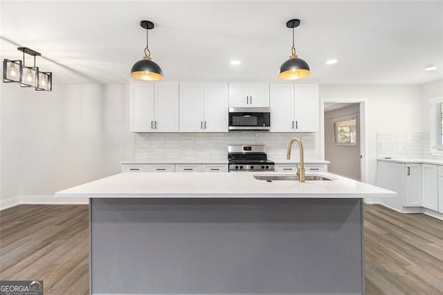 kitchen featuring sink, an island with sink, pendant lighting, and appliances with stainless steel finishes