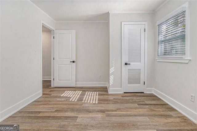 unfurnished room featuring light wood-type flooring and ornamental molding