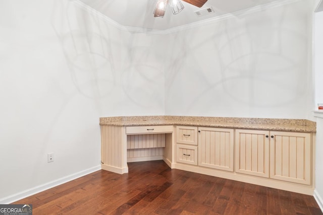 interior space with ceiling fan, dark hardwood / wood-style floors, built in desk, and crown molding