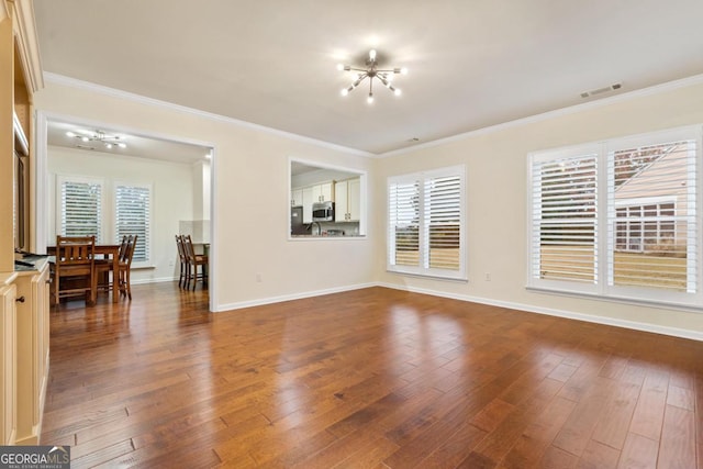 living room with a chandelier, wood-type flooring, and crown molding