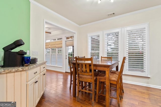 dining space with hardwood / wood-style floors and crown molding