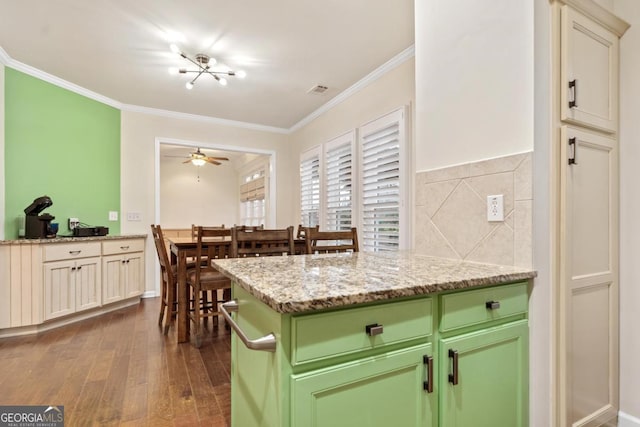 kitchen featuring crown molding, ceiling fan, dark hardwood / wood-style floors, decorative backsplash, and light stone counters