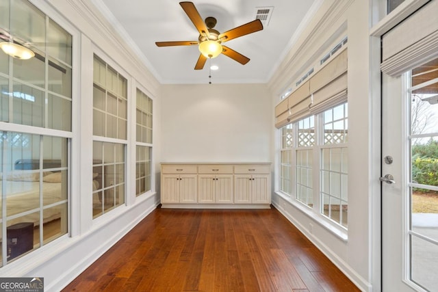 unfurnished sunroom featuring ceiling fan