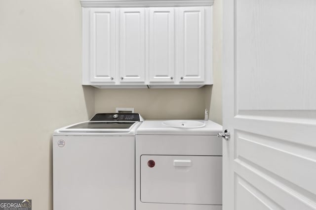 washroom with washer and clothes dryer and cabinets