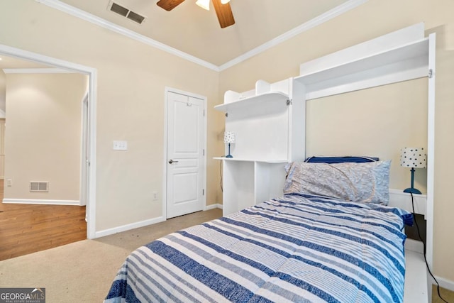 carpeted bedroom featuring ceiling fan and ornamental molding