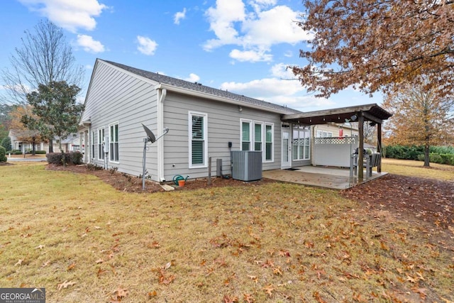 rear view of house with a yard, cooling unit, and a patio area