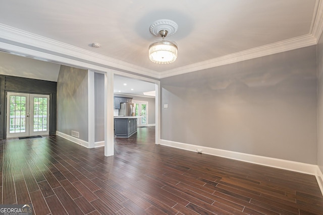 empty room featuring dark hardwood / wood-style floors, ornamental molding, and french doors