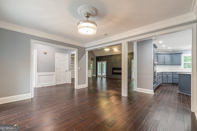 unfurnished living room with dark wood-type flooring and ornamental molding