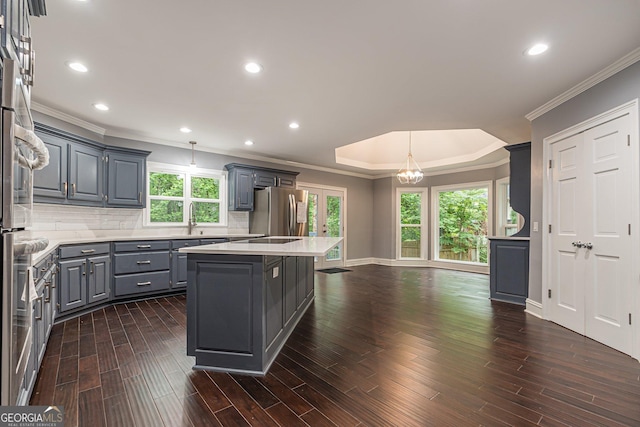 kitchen featuring stainless steel refrigerator, a center island, hanging light fixtures, tasteful backsplash, and gray cabinets