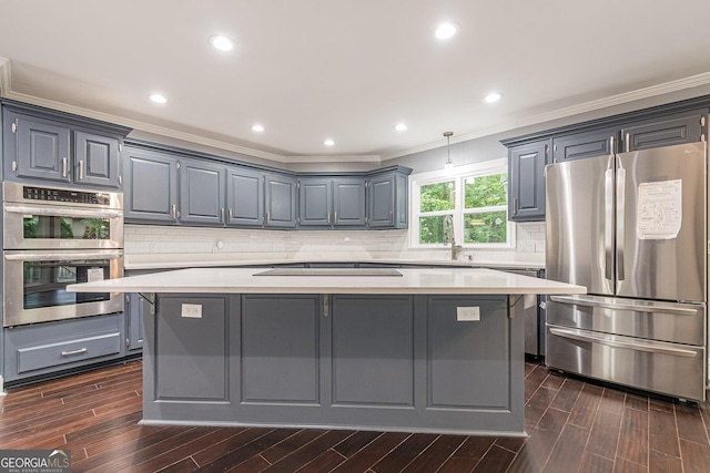 kitchen with gray cabinets, decorative backsplash, a kitchen island, and stainless steel appliances