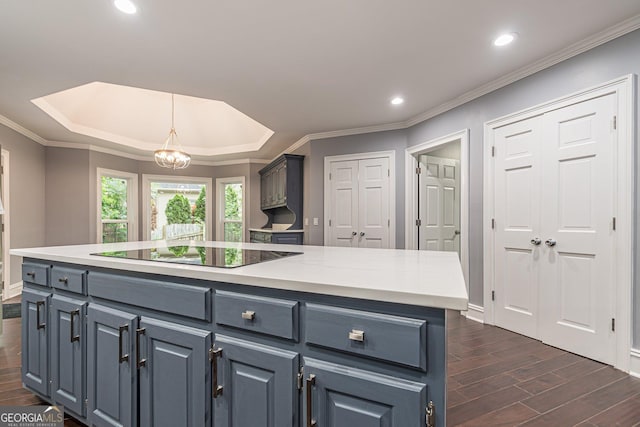 kitchen featuring a center island, black electric stovetop, crown molding, hanging light fixtures, and a chandelier