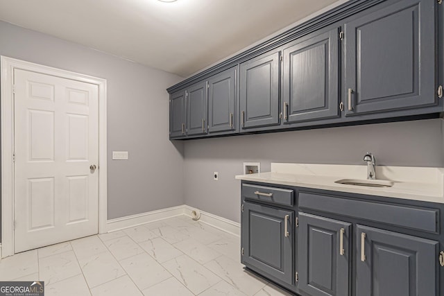 laundry room featuring electric dryer hookup, hookup for a washing machine, cabinets, and sink