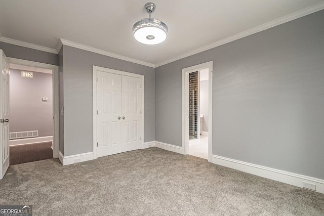 unfurnished bedroom with carpet flooring, a closet, and ornamental molding