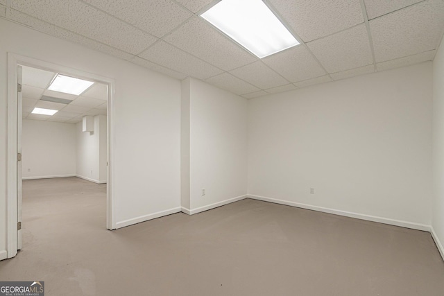 empty room featuring concrete floors and a paneled ceiling