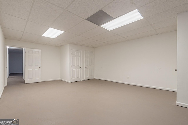 basement featuring a drop ceiling and carpet floors