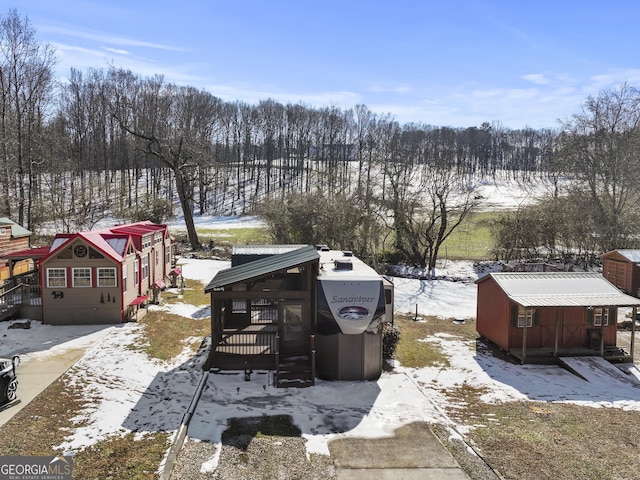 yard covered in snow with an outbuilding and a storage unit