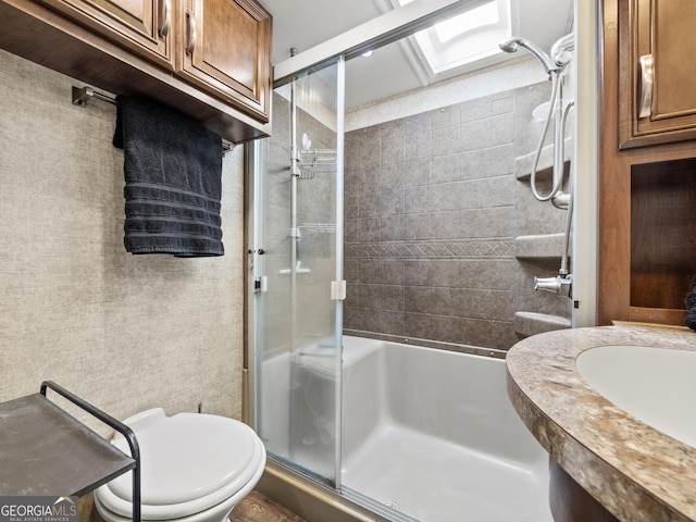 bathroom with toilet, a shower with door, and a skylight