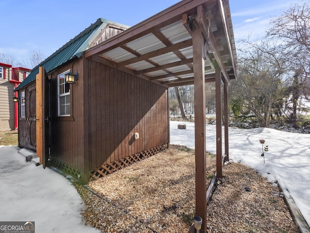 view of snowy exterior with an outdoor structure