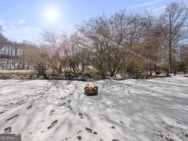 yard covered in snow with an outdoor fire pit