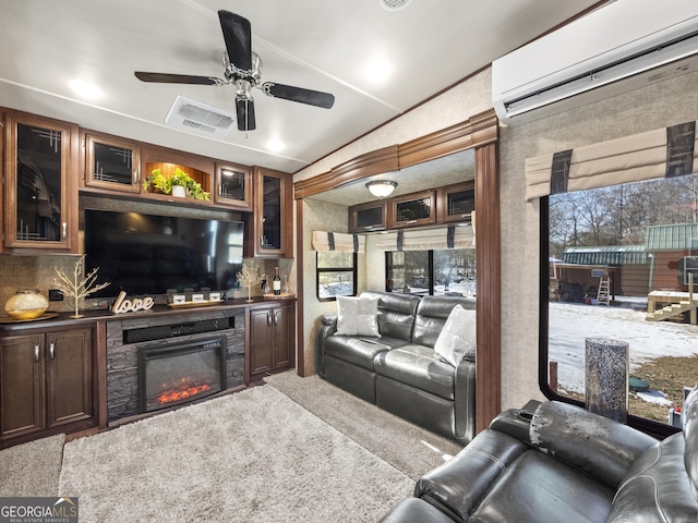 carpeted living room featuring ceiling fan and a wall mounted AC