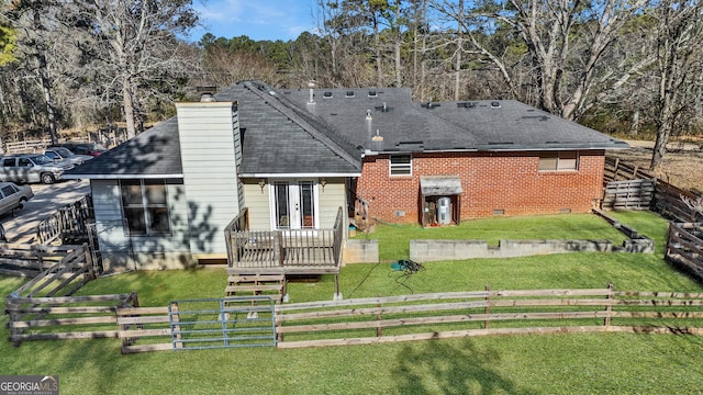 back of house with french doors, a deck, and a lawn