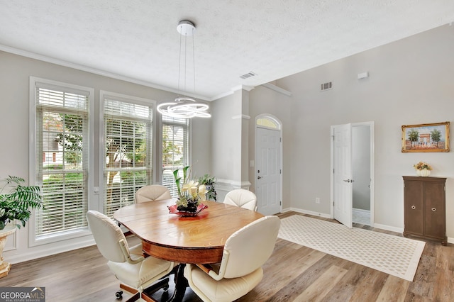 dining area featuring a textured ceiling and light hardwood / wood-style floors