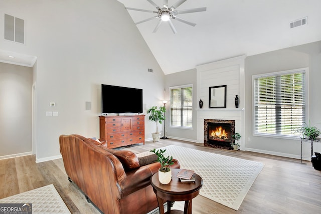 living room featuring light wood-type flooring, high vaulted ceiling, and ceiling fan