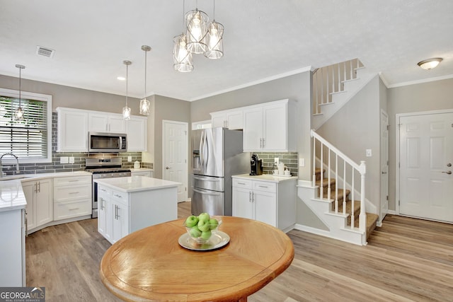 kitchen featuring decorative light fixtures, backsplash, stainless steel appliances, and a kitchen island