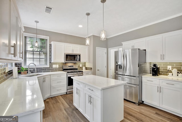 kitchen with sink, a center island, pendant lighting, white cabinets, and appliances with stainless steel finishes