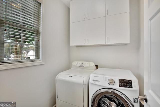 washroom featuring washer and dryer and cabinets