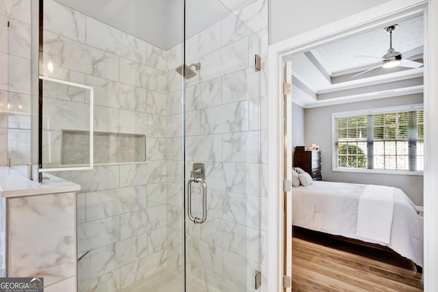 bathroom with hardwood / wood-style floors, a shower with door, and ceiling fan