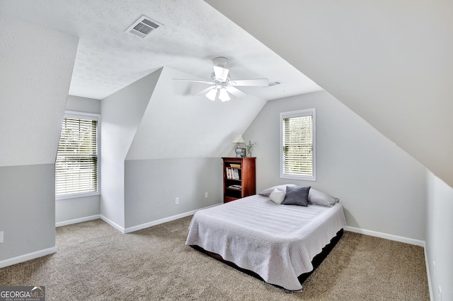 bedroom featuring carpet flooring, ceiling fan, a textured ceiling, and vaulted ceiling