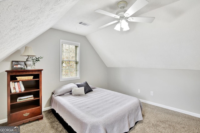 carpeted bedroom with vaulted ceiling, ceiling fan, and a textured ceiling