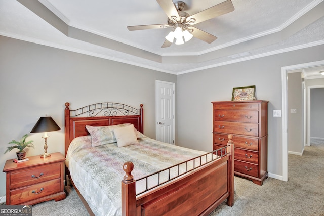 carpeted bedroom featuring ceiling fan, a raised ceiling, and ornamental molding