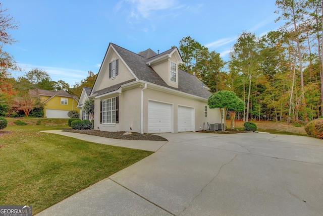 view of home's exterior featuring a yard, a garage, and central AC unit