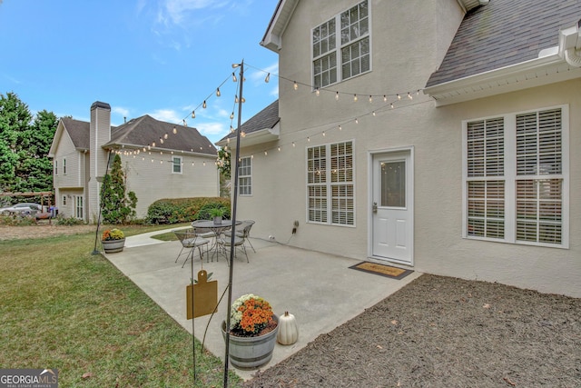 back of house featuring a lawn and a patio