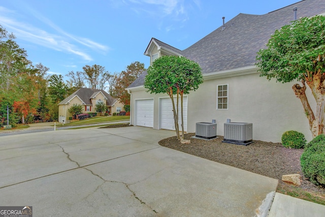 view of property exterior with a garage and cooling unit