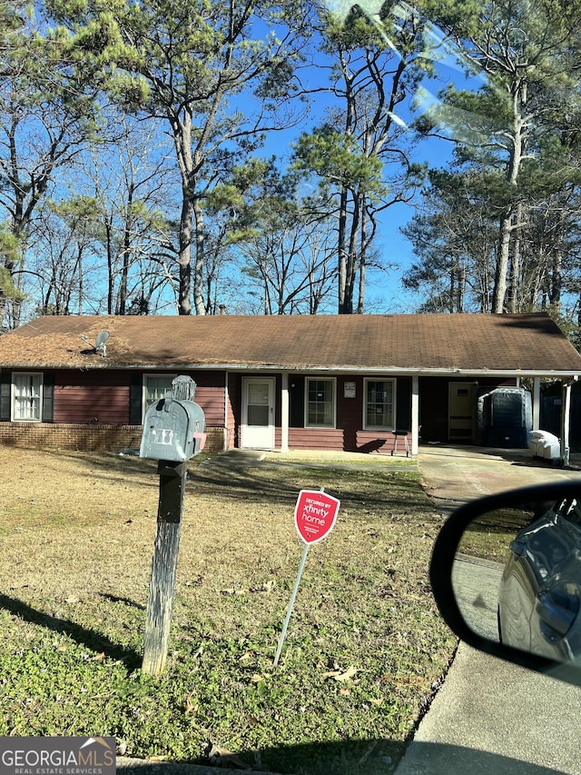 ranch-style house with a carport and a front lawn