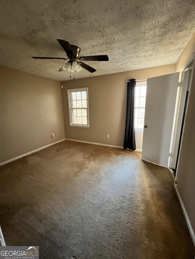 carpeted spare room with ceiling fan and a textured ceiling